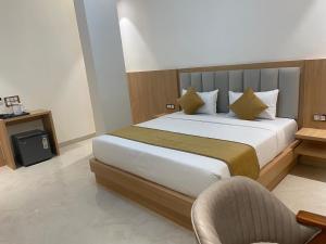 a bedroom with a large bed and a chair at Hotel Immense Plaza in Jāmb