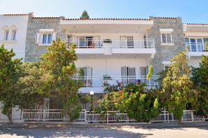 a large white building with trees in front of it at Hotel Anna Apartments in Kokkini Khanion