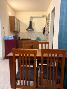 a kitchen with a wooden dining table and chairs at New Moon Resort in Chennai