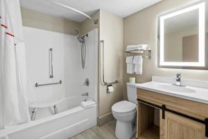a bathroom with a sink and a toilet and a mirror at Red Roof Inn Ames in Ames +29 photos