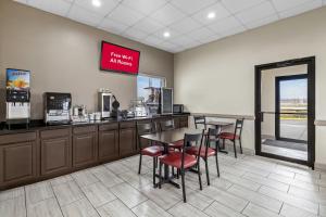 a restaurant with a counter and chairs and a table at Red Roof Inn Ames in Ames