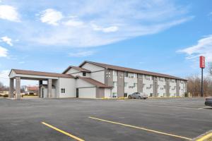a large white building with a parking lot at Red Roof Inn Ames in Ames