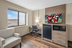 a hotel room with a tv and a desk with a chair at Red Roof Inn Ames in Ames