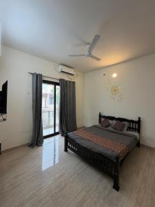 a bedroom with a bed and a ceiling fan at New Moon Resort in Chennai +18 photos