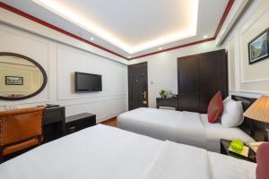 a hotel room with two beds and a television at Viet Hotel in Hanoi