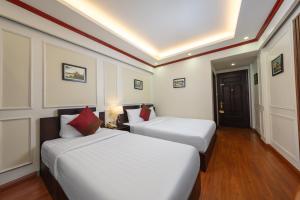 a hotel room with two beds and a door at Viet Hotel in Hanoi