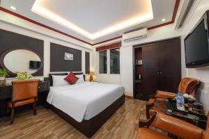 a bedroom with a bed and a desk and a tv at Viet Hotel in Hanoi