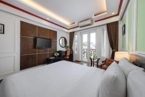 a bedroom with a large white bed and a television at Viet Hotel in Hanoi