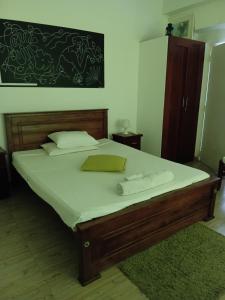 a bed with white sheets and a green pillow on it at Angels Negombo in Negombo