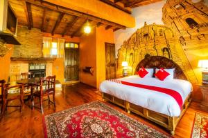 a bedroom with a large bed and a dining room at OYO Hotel El Mineral, Tlalpujahua in Tlalpujahua de Rayón