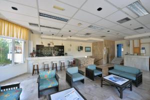 a lobby with chairs and a bar in a building at Hotel Anna Apartments in Kokkini Khanion