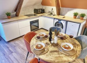 a kitchen with a wooden table with bowls of food at La casa Terracotta - centre ville , spacieux & confortable in Béthune