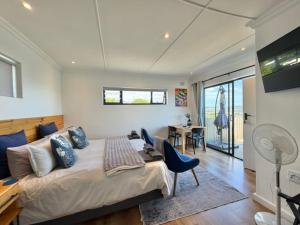 a bedroom with a bed and a desk and a television at De View in Knysna