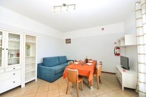 a living room with a table and a blue couch at Villaggio dei Fiori in Caorle