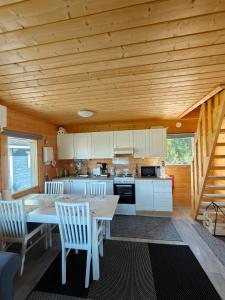 a kitchen with a table and chairs in a cabin at Lomamökki seitsemisen kansallispuiston lähellä in Aurekoski +24 photos