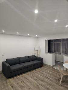 a living room with a black couch and a table at Trusted Home in Târgovişte