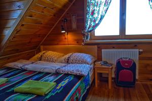 a bedroom with a bed in a wooden cabin at Agroturystyka Żabi Raj in Pokrzywnica
