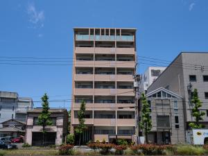 a tall apartment building in a city at 旅鴉 inn 高松 - 高松駅徒歩5分 in Takamatsu