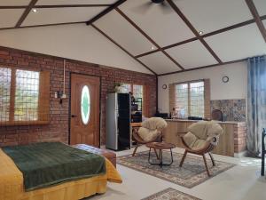 a bedroom with two chairs and a brick wall at Forest Pool Villa in Ulu Melaka
