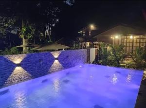 a swimming pool at night with blue lights at Forest Pool Villa in Ulu Melaka