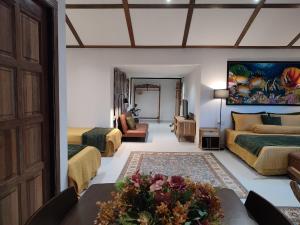a bedroom with two beds and a living room with a table at Forest Pool Villa in Ulu Melaka