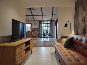 a living room with a television and a couch at Forest Pool Villa in Ulu Melaka +1 photo