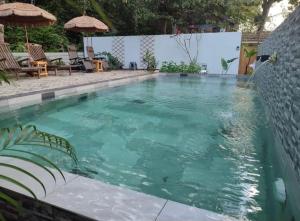 a swimming pool with green water in a yard at Forest Pool Villa in Ulu Melaka