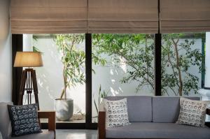 a living room with a couch and a large window at Casa18Villa in Kiribathgoda