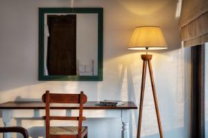 a table with a chair and a lamp and a mirror at Casa18Villa in Kiribathgoda