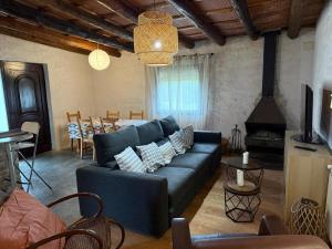 a living room with a blue couch and a fireplace at La Caseta del Mas Valls in Rupiá