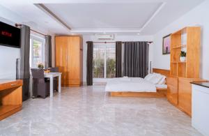 a bedroom with a bed and a desk and a television at The July - Coliving by Kegotel in Vung Tau