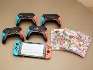 two video game controllers and a cell phone and a book at 旅鴉 inn 高松 - 高松駅徒歩5分 in Takamatsu
