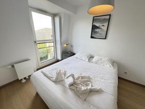 a white bed in a room with a window at Appartement moderne Senlis in Senlis