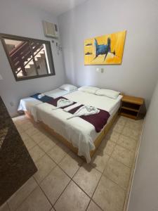 a bedroom with a bed and a painting on the wall at Pousada Refúgio da Ilha in São Mateus
