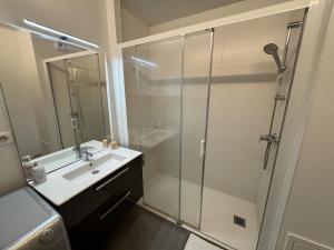 a bathroom with a glass shower and a sink at Appartement moderne Senlis in Senlis +14 photos