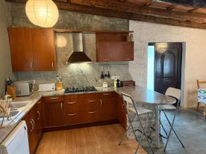 a kitchen with wooden cabinets and a table with chairs at La Caseta del Mas Valls in Rupiá