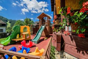 a backyard with a playground with a slide and play equipment at Dom Chata Kowala in Szczawnica