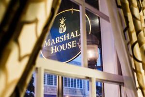 a sign for a marshall house on a window at The Marshall House, Historic Inns of Savannah Collection in Savannah