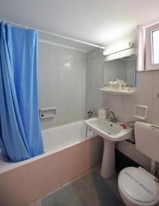 a bathroom with a toilet and a tub and a sink at Hotel Anna Apartments in Kokkini Khanion