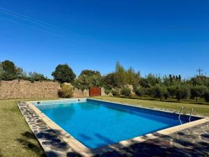 a large blue swimming pool in a yard at La Caseta del Mas Valls in Rupiá