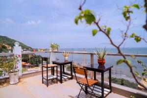 a balcony with two tables and chairs and the ocean at The July - Coliving by Kegotel in Vung Tau