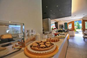a kitchen with a buffet with a cake on a counter at Garni Sayonara in Moena