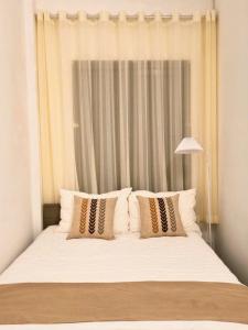 a white bed with pillows in a bedroom at Old Quarter Lake House in Hanoi