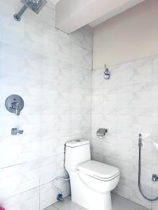 a white bathroom with a toilet and a shower at The Himalayan Ridge in Kathmandu