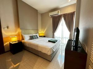a bedroom with a bed and a tv and a window at The Villa Jomtien Pattaya By Ahmed in Jomtien Beach +45 photos