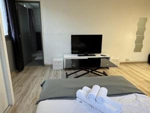 a room with a bed with a tv and two white gloves at Studio fonctionnel Beauvais in Beauvais