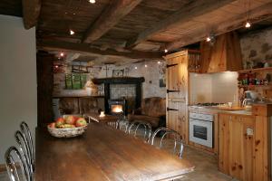 a kitchen with a wooden table with a bowl of fruit at Gite E'table Charlannes in Hautefage