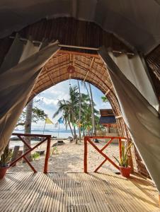 a view of the beach through an archway on a beach at EL-NARA SEASIDE Beach Resort in El Nido