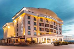 a hotel with a lit up facade at night at Karpalas City Hotel & Spa in Bolu