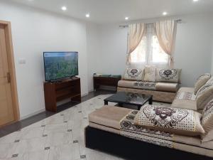a living room with a couch and a flat screen tv at l'Abrit tranquille 3 in Tefeschoun